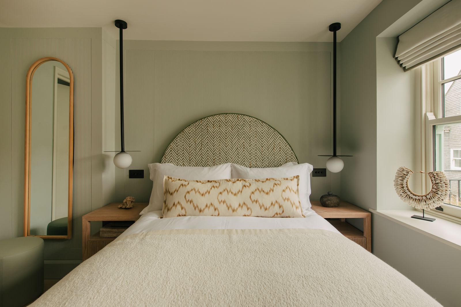 Bedroom with arched mirror in the seaside cottage